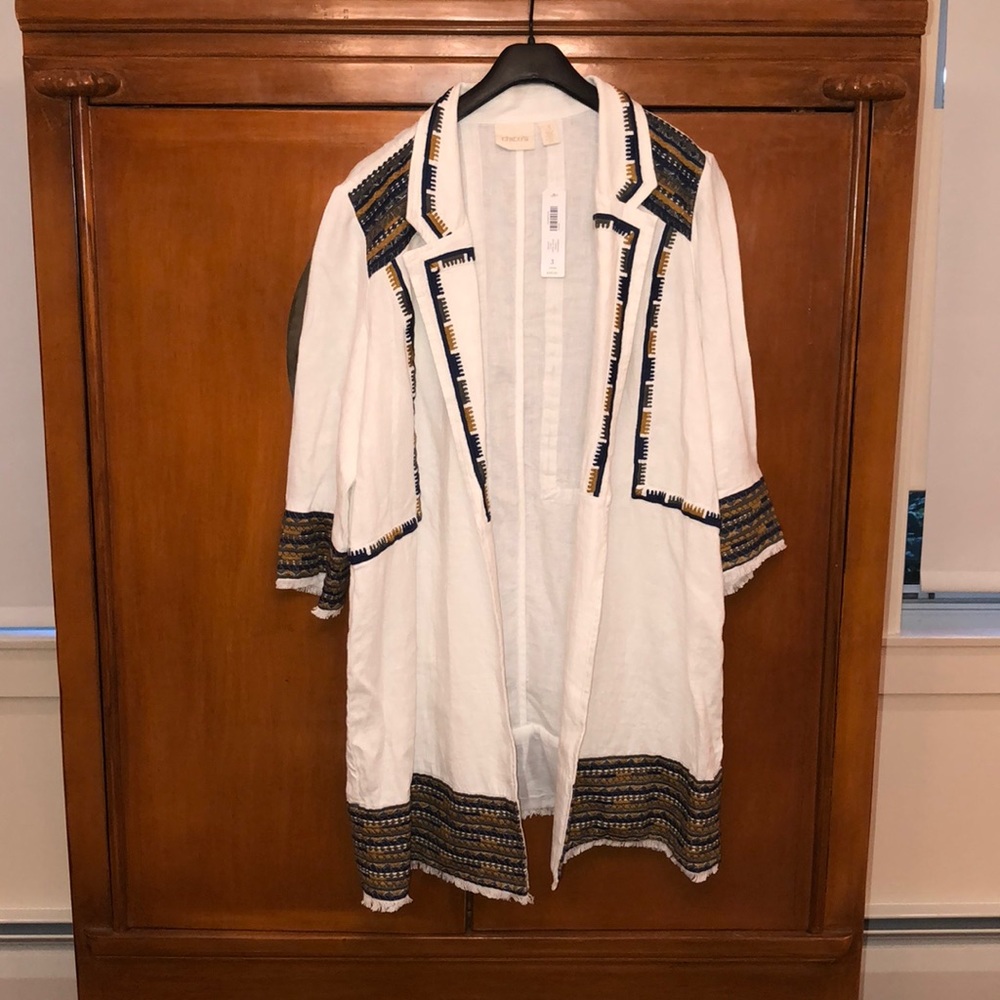 All white jacket with multi colored Aztec border .